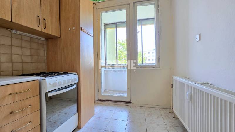 A kitchen in a 3-room apartment with a gas stove and access to a loggia.