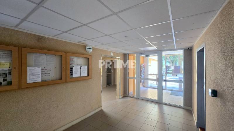 The entrance hall of the apartment building with information boards, secured by a security camera system.