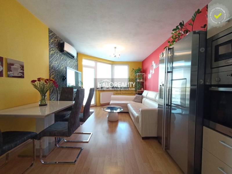 The living room with a dining area in the 2-room apartment has yellow and red walls, a sofa.