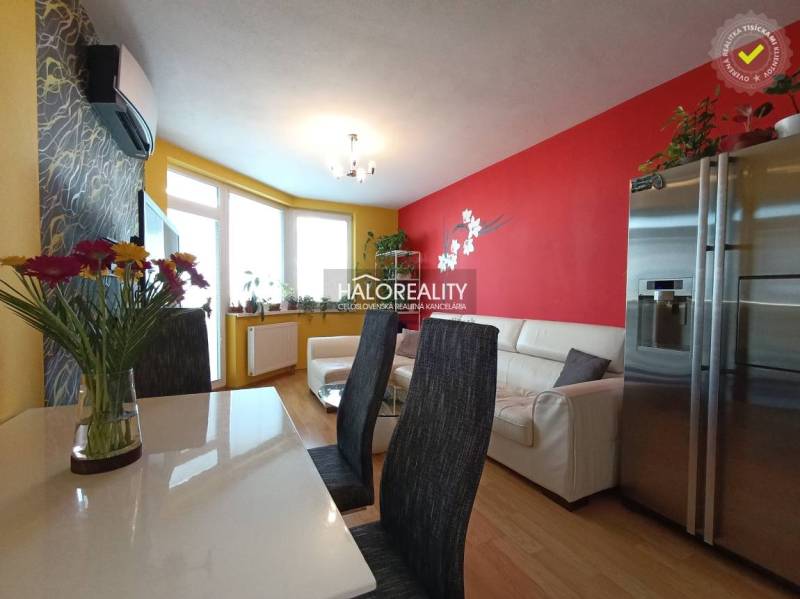Living room in a two-room apartment with colorful walls, a sofa, and a dining table.