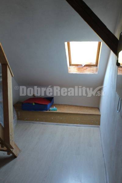 Attic room in a family house with a skylight and a wooden bench.