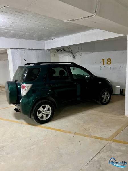 The car is parked in the garage at parking spot number 18.