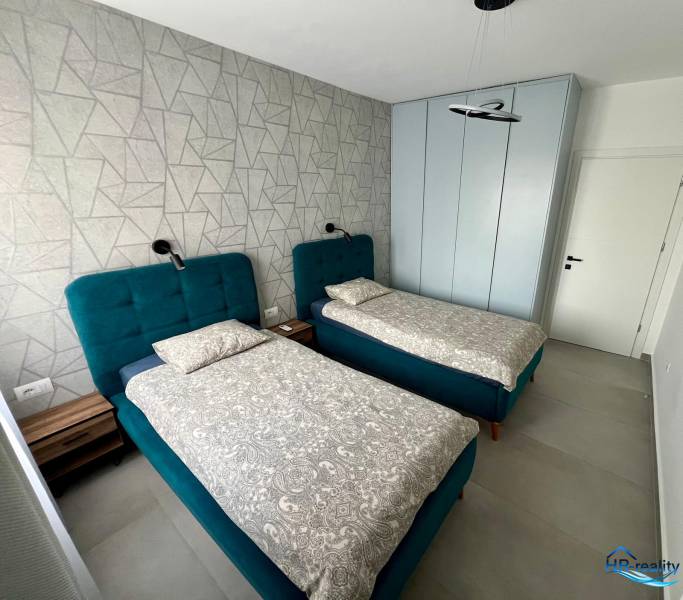 Double room with blue beds and a patterned wall in the Holiday Apartment.