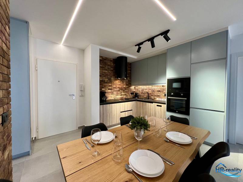 Kitchen in the Holiday Apartment with a dining table, brick cladding, and modern appliances.