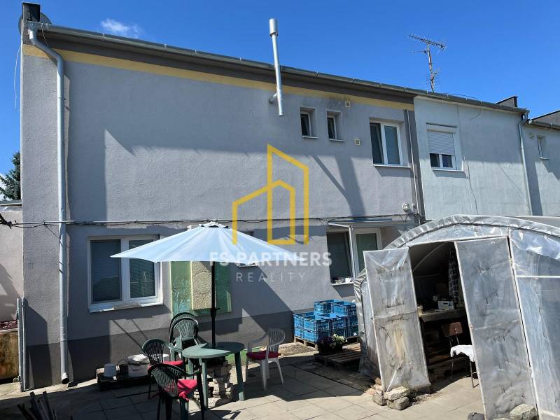 A family house in Komárno with a yard, seating area, and enclosed shelter.