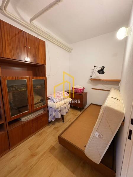 A small room with antique furniture and a fold-out bed in a family house.