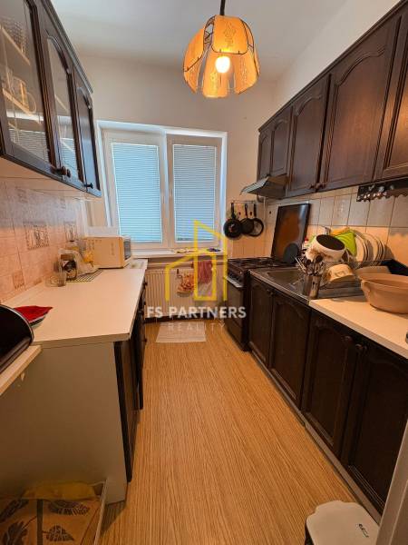 A kitchen in a family house with wooden cabinets and appliances.