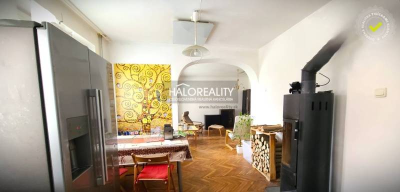 Interior of a family house with colorful wall painting, refrigerator, and fireplace.