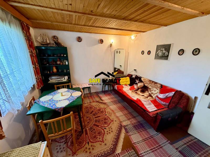 Living room in a cabin with a wooden ceiling, patterned rugs, and comfortable seating.