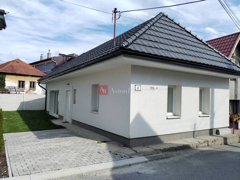 A family house in Turč. Kľačany, Martin, with light plaster, a paved walkway, and a small lawn.