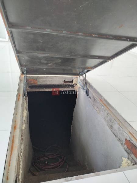 Basement with stairs and an open hatch in a family house.