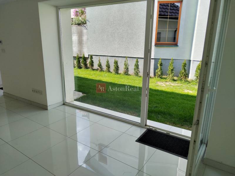 Interior of a family house, white floor, large window with a view of the garden.