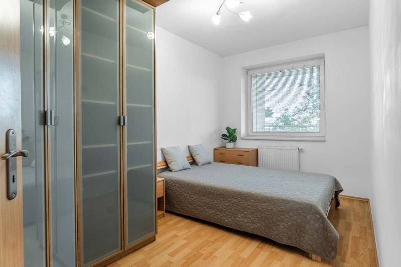 Bedroom in a 2-room apartment with a double bed, built-in wardrobe, and dresser.