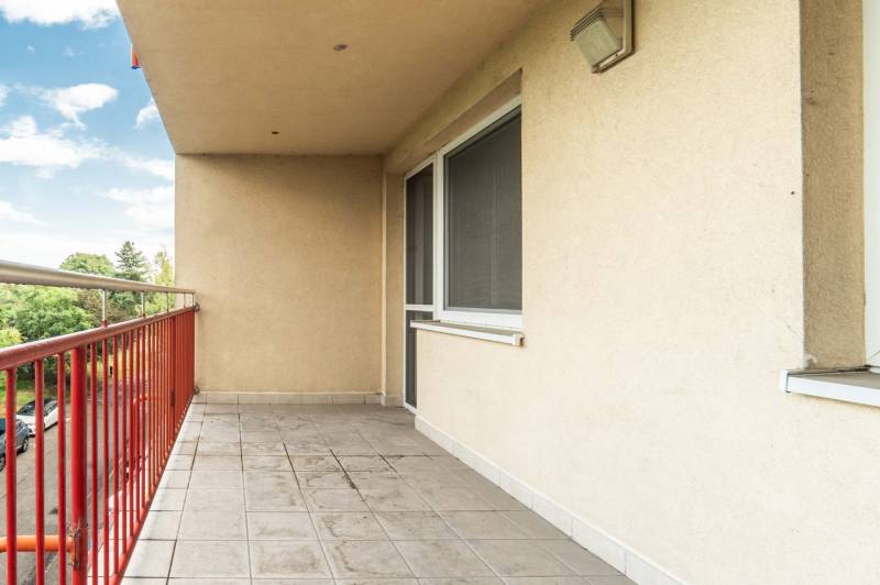 A balcony with tiles and a red railing in a 2-room apartment, Mierová Street, Bratislava - Ružinov.
