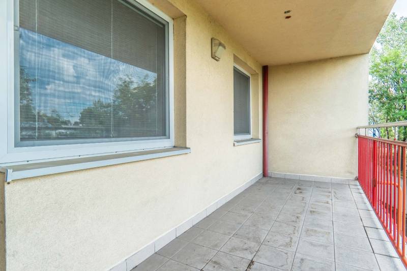 A balcony with tiles and two windows in a 2-room apartment.