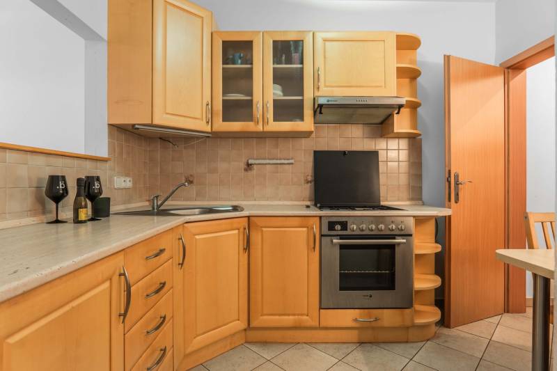 A kitchen with a corner unit, stove, and bar accessories in a 2-room apartment.