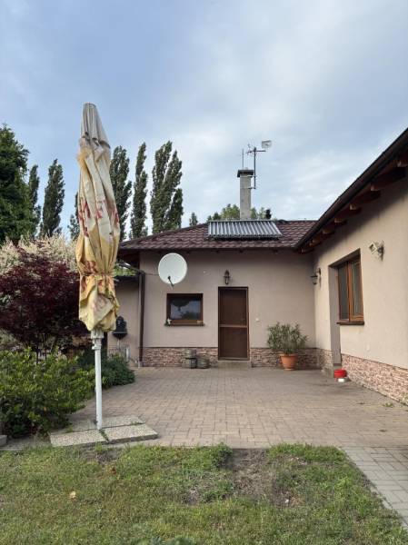 Family house in Malacky, front yard with terrace, greenery, and satellite dish.