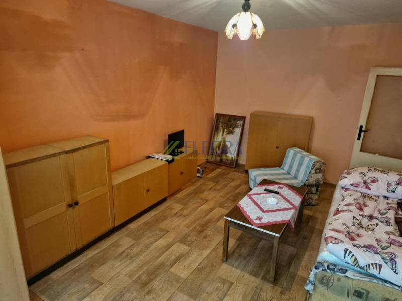 A room with wooden furniture and an armchair in a studio apartment.