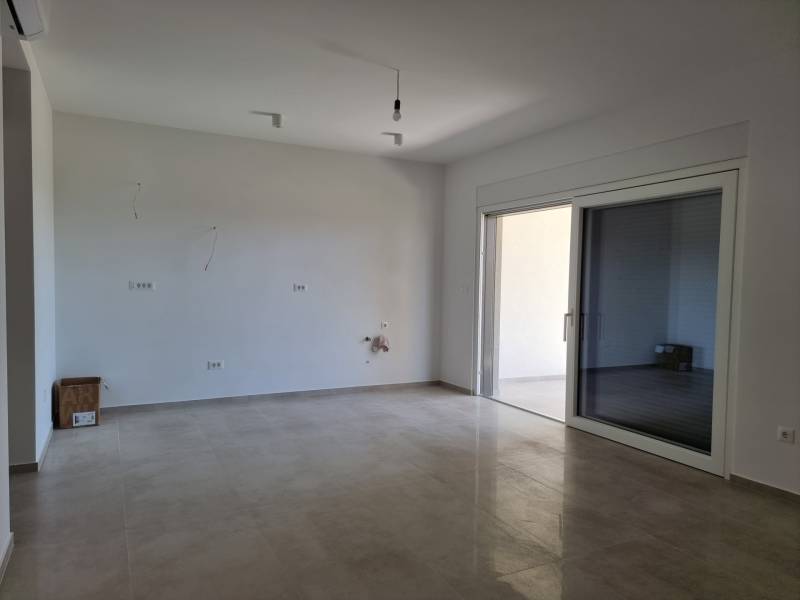 Spacious interior of a new 4-room apartment with large glass doors and tiling.