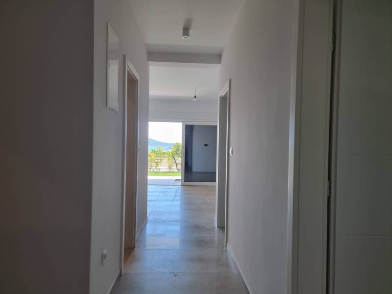 A hallway in a 4-room apartment with a view of the exterior and greenery.
