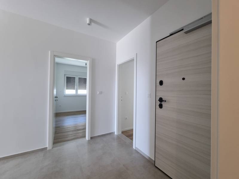 Entrance hallway in a 4-room apartment with wooden doors and tiles.