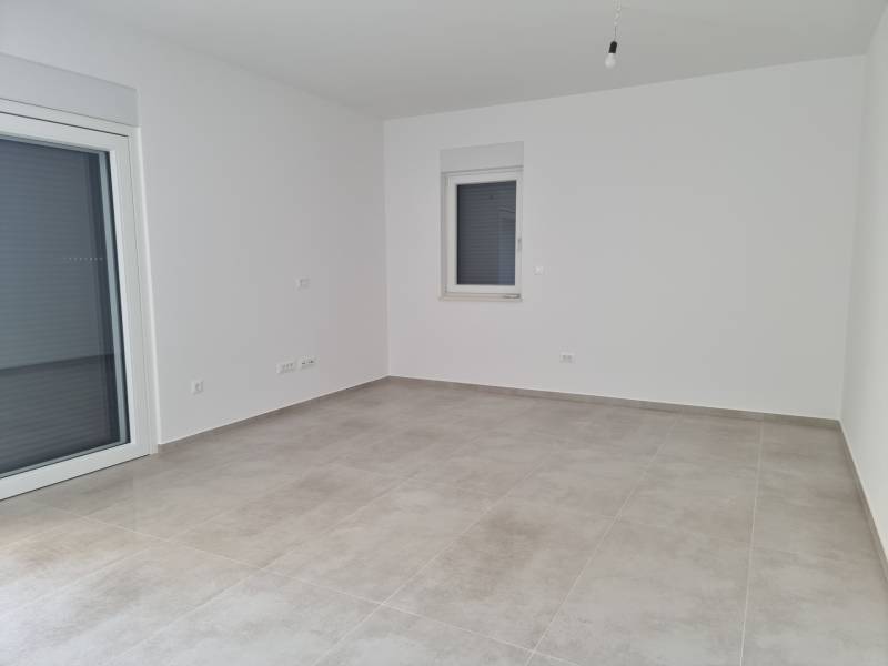 An empty room with light walls and tiles in a 4-room apartment.
