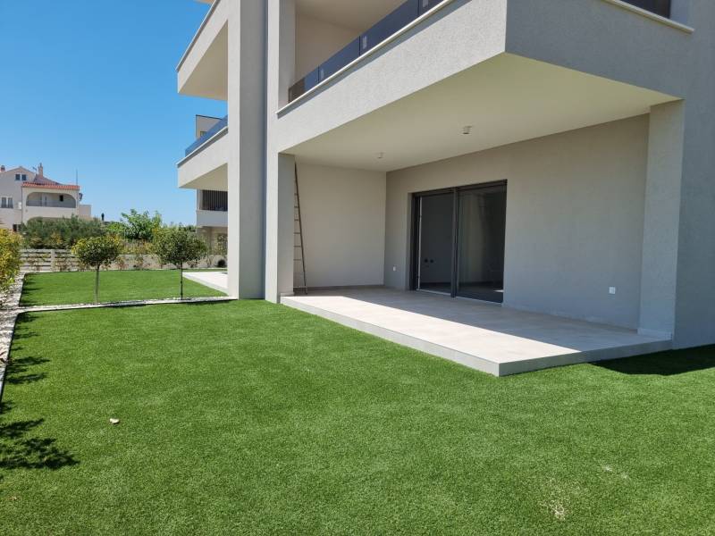 Exterior of a 3-bedroom apartment in Vodice with a lawn and terrace in the Croatian scenery.