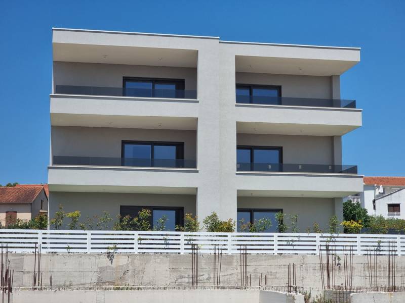 An apartment building in the city of Vodice with three floors and glass balconies.