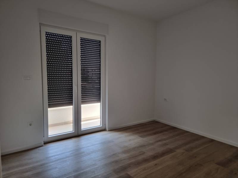 A room with drawn blinds and floating floor in a 4-room apartment.