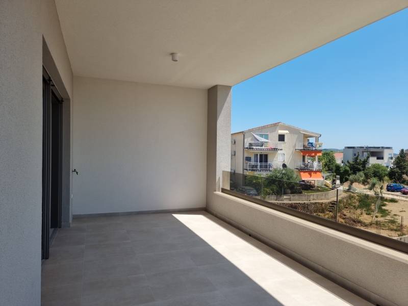 A balcony in a 4-room apartment in Vodice with a view of the surrounding buildings and greenery.