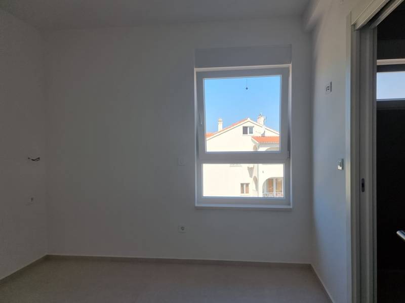 A room in a 4-room apartment with a view of the garden, bright walls, window.