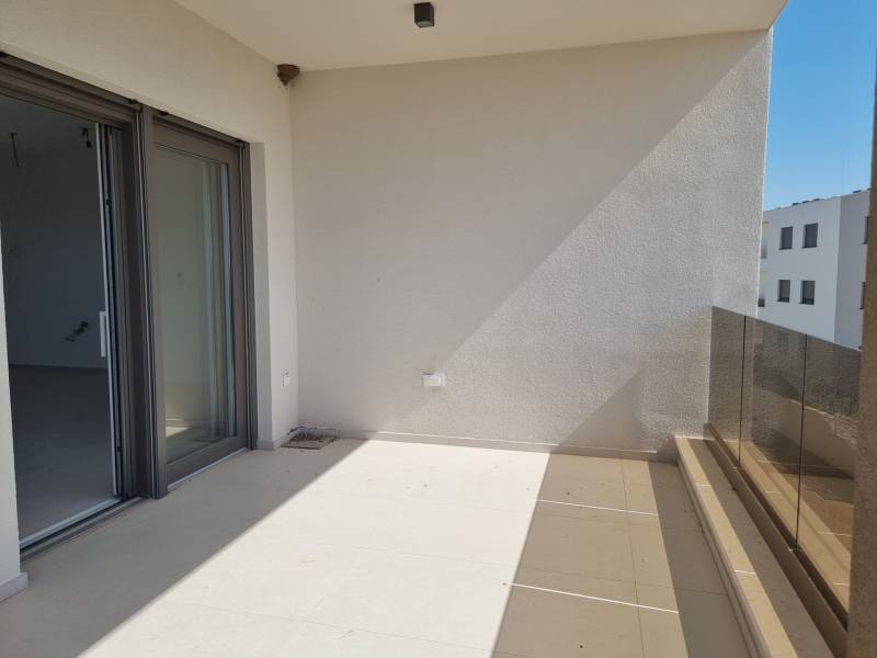 Balcony of a 4-room apartment in Vodice with glass railings and sliding doors.