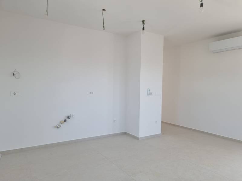 An empty room in a 4-room apartment with spotlights and air conditioning.