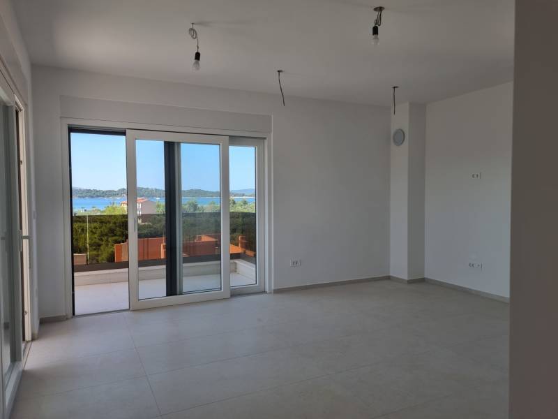 Spacious interior of a 4-room apartment with a view of the sea through large windows.