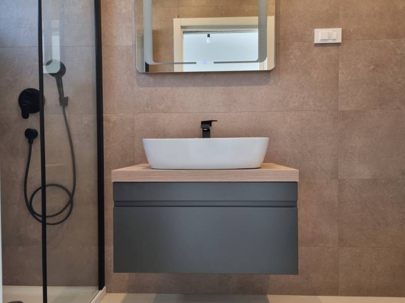 A bathroom in a 4-room apartment with a modern sink and a shower.