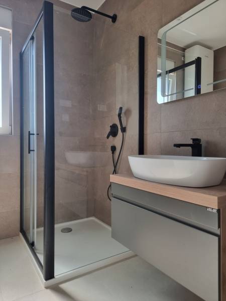 A bathroom with a shower and a sink in a 4-room apartment.