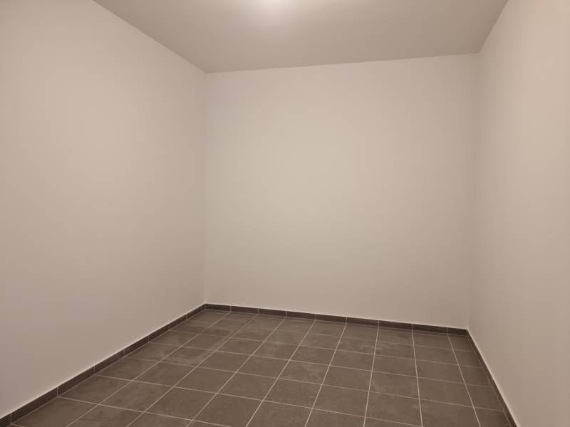 Empty room with gray tiles in a 4-room apartment.