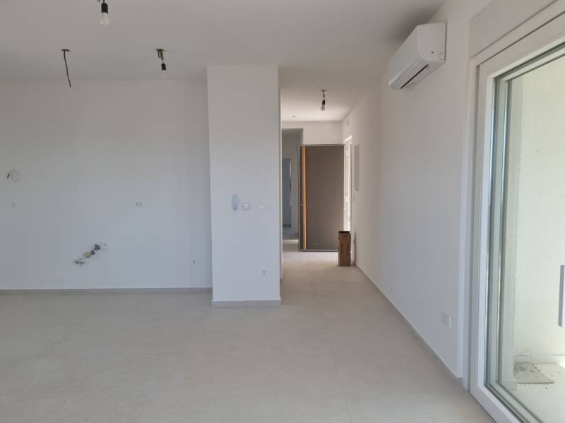 Spacious interior of a 4-room apartment with white walls and air conditioning.