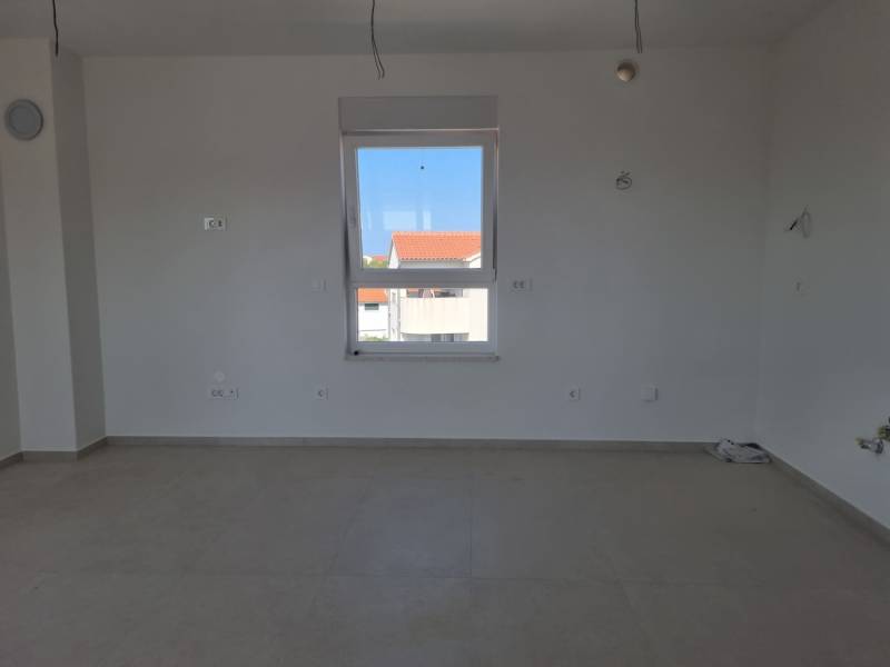 A bright room with white walls and a window in a 4-room apartment.