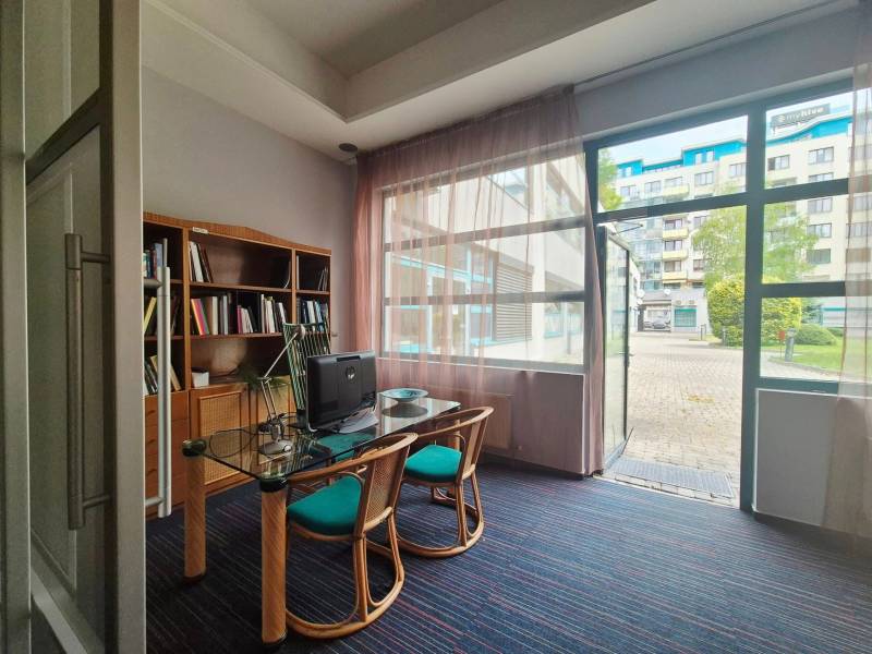 Interior of a commercial space with furniture and a view of glass doors leading outside.