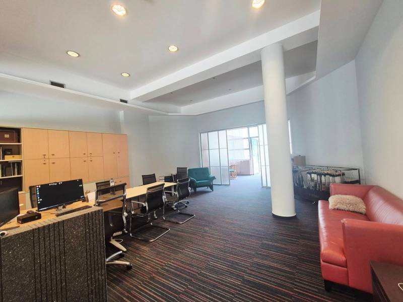 Office spaces with workstations, a sofa, and cabinets under the ceiling.