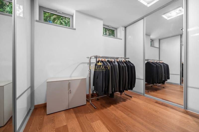 A wardrobe in a family house with a mirrored closet and clothes hangers.