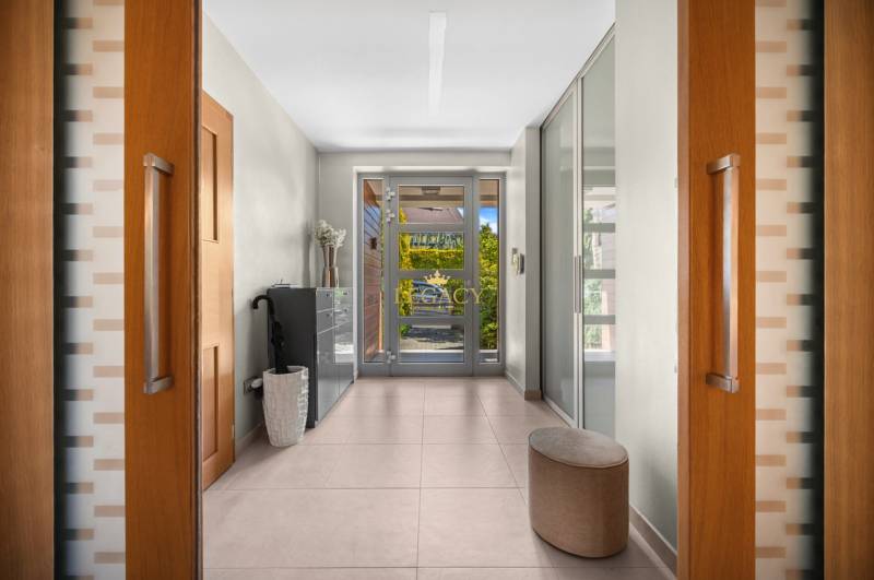Interior of a family house with a hallway, glass doors, and tiles.