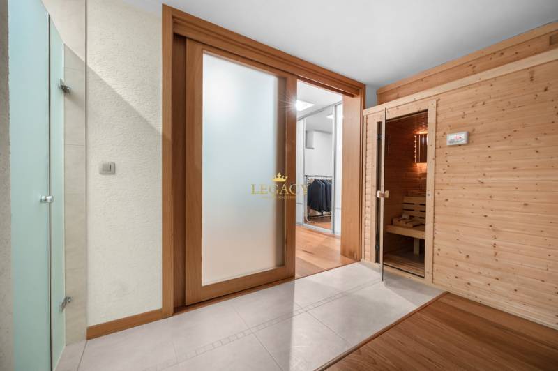 Interior of a family house with glass sliding doors and a wooden sauna.