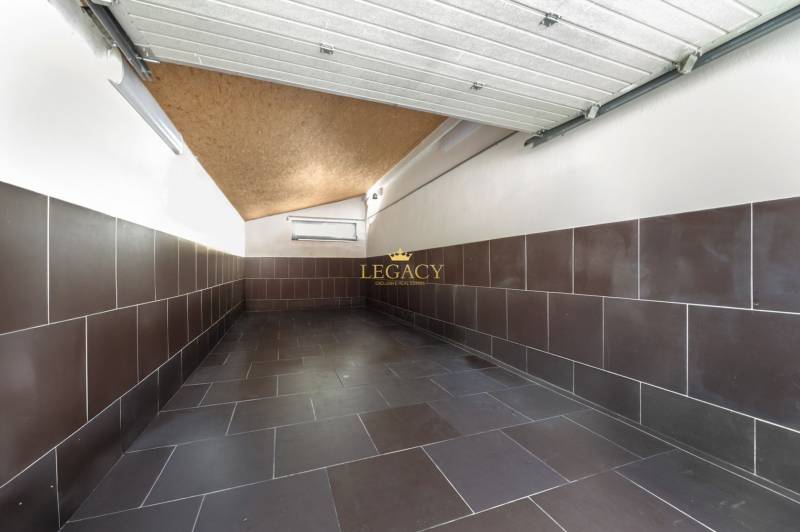 A garage with ceramic tiles in a family house, walls covered with brown cladding.
