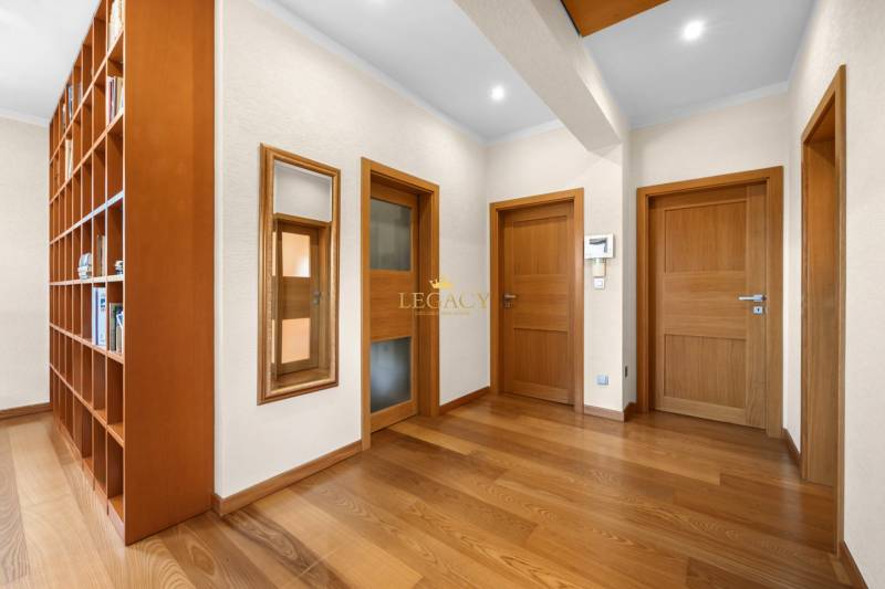 Hallway of a family house with wooden doors and a shelving system.