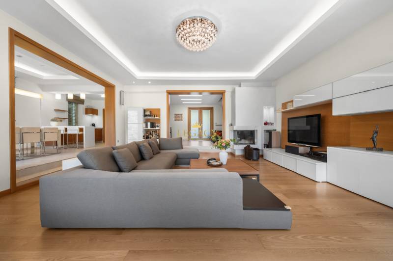 Living room in a family house with a large gray couch and white furniture.