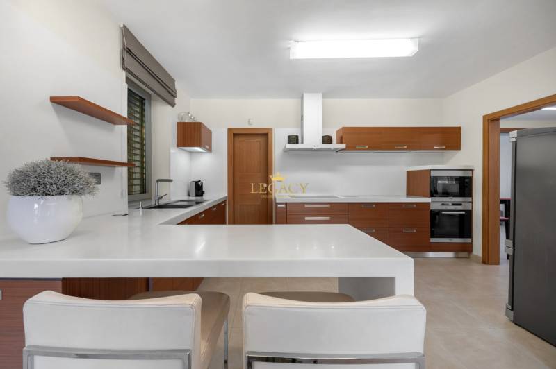 A kitchen in a family house with built-in appliances and wooden kitchen cabinets.
