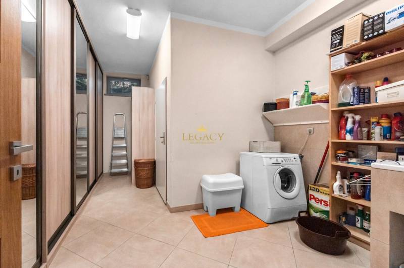 Laundry room in a family house with a washing machine, shelves for cleaning products, and storage space.
