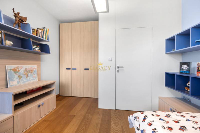 A children's room in a family house with wooden floors and shelves full of books.